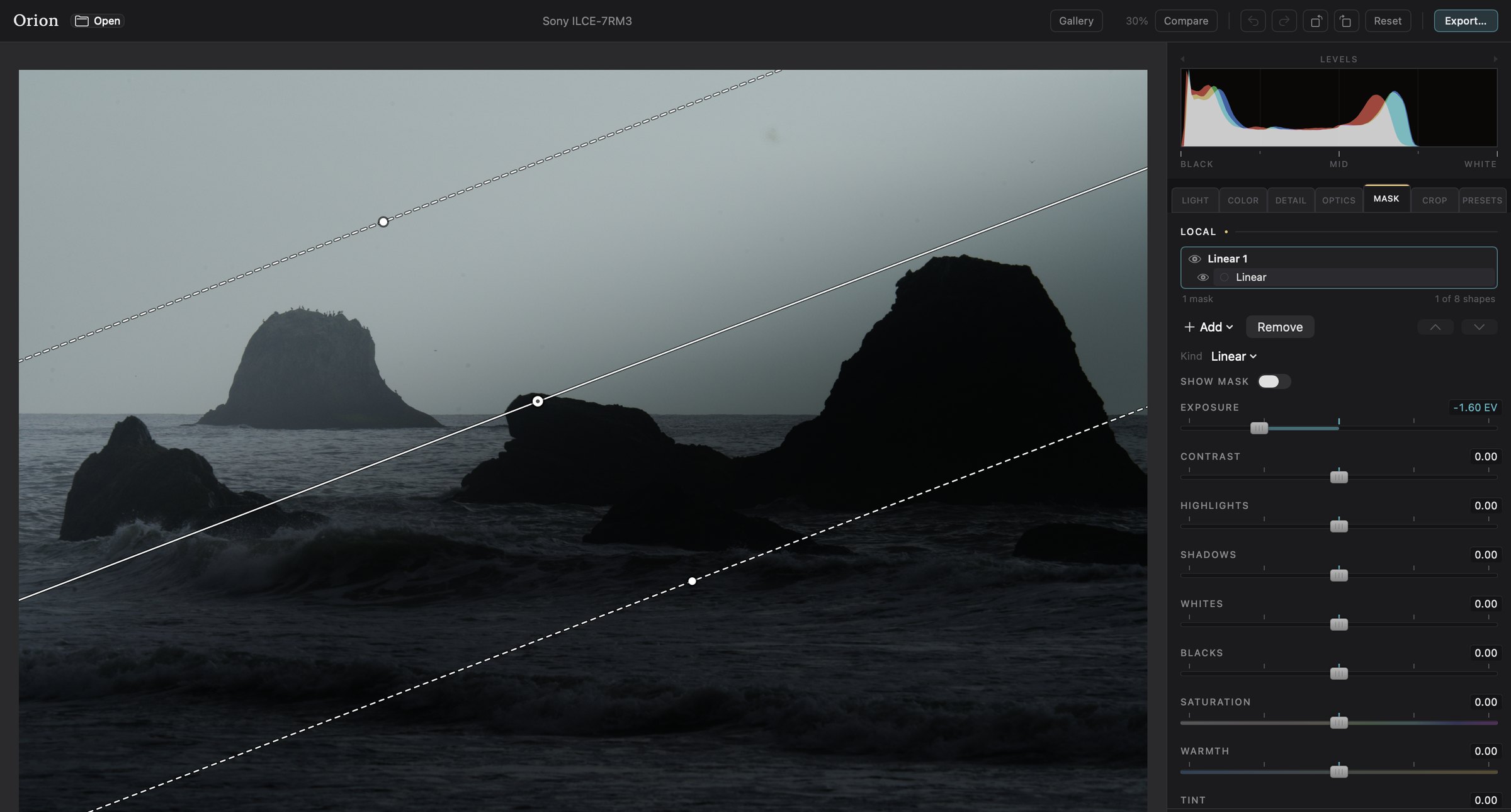 Orion's window: the sea stacks with a linear mask drawn across the sky, and the Mask panel holding its exposure at minus 1.60 EV.